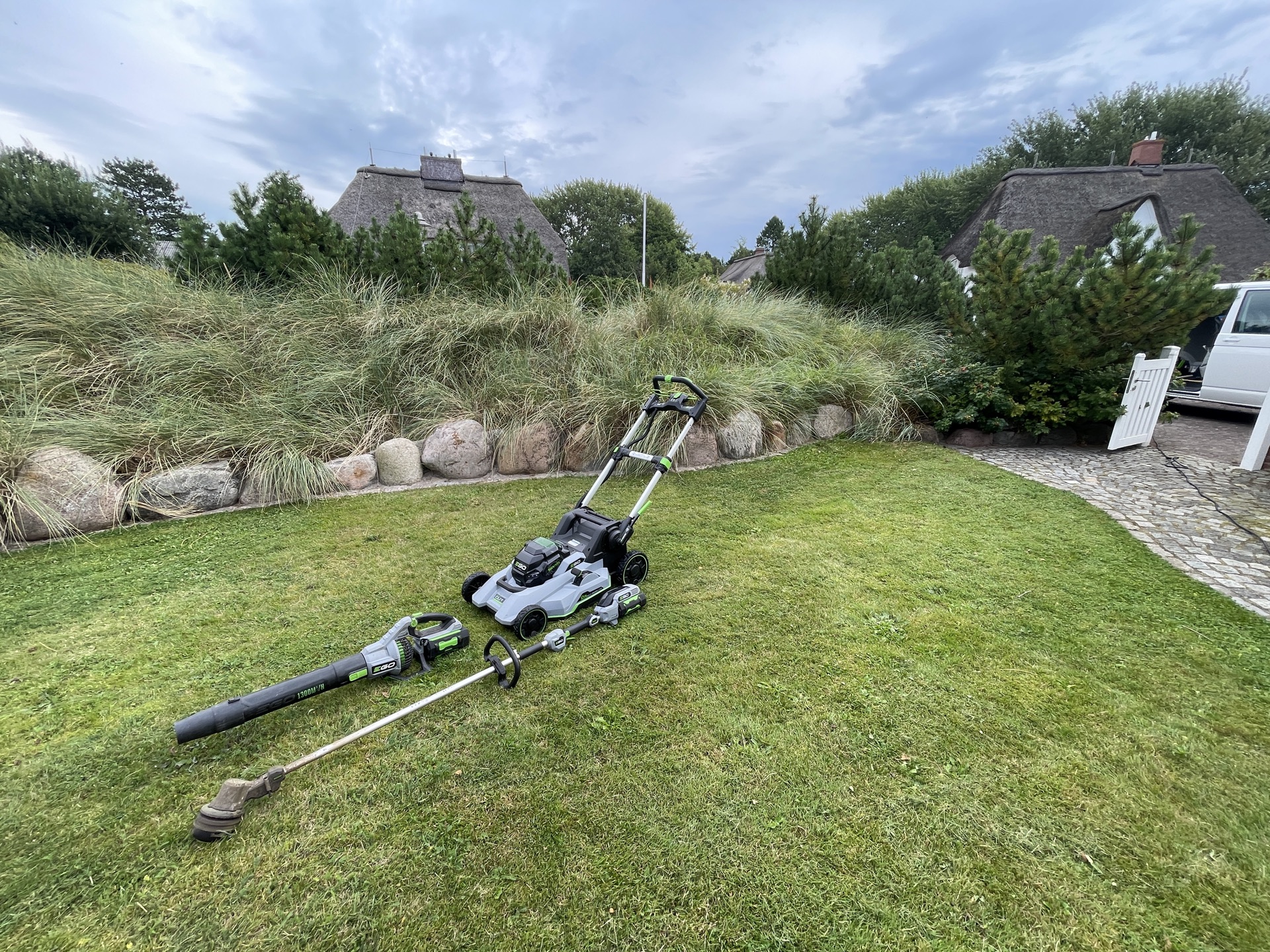 Rasenpflege mit Akku-Mäher und Trimmer an einem Ferienhaus an der Nordseeküste